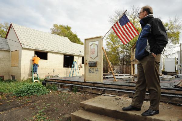 David Myers, Director of the DHS Center for Faith-based and Neighborhood Partnerships, stands by the steps and door front remains of a flooded Minot home.