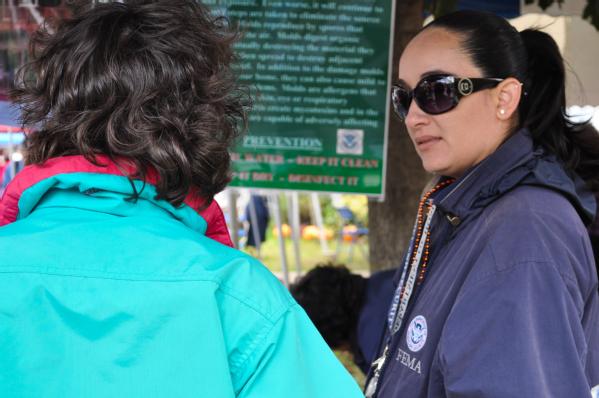 Schoharie, NY, October 15, 2011 -- Dimaldy Cruz-Carlo, Mitigation Specialist speaks to a disaster survivor at the Schoharie Flood Benefit about preparing for future disasters, flood insurance and rebuilding safe and stronger homes. FEMA plays a vital role supporting State, Tribal and local governments as they respond to the impacts of Hurricane Irene.