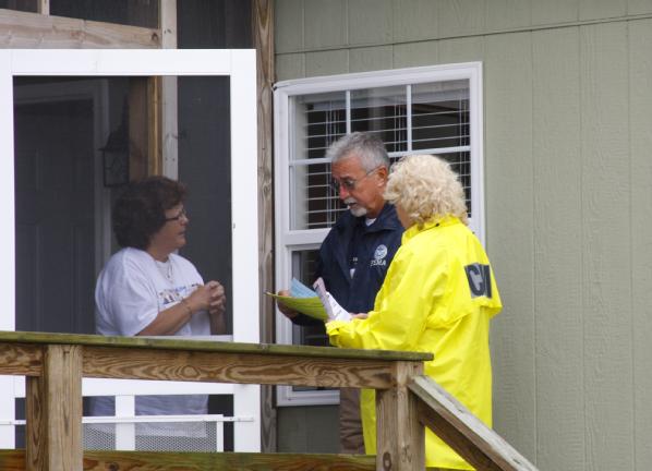 State and FEMA representatives check on a survivor of Hurricane Irene in a community that was hit by high storm surge.