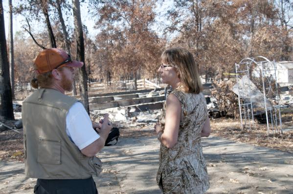 A FEMA Housing Inspector talks with a home owner whose home was destroyed when a wildfire raced through her community.