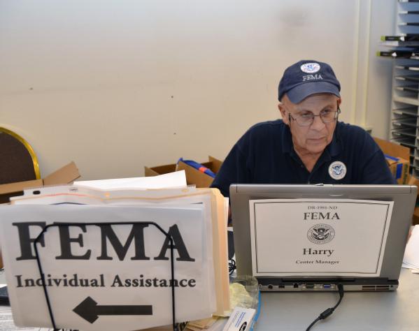 A FEMA employee works at a disaster recovery center.