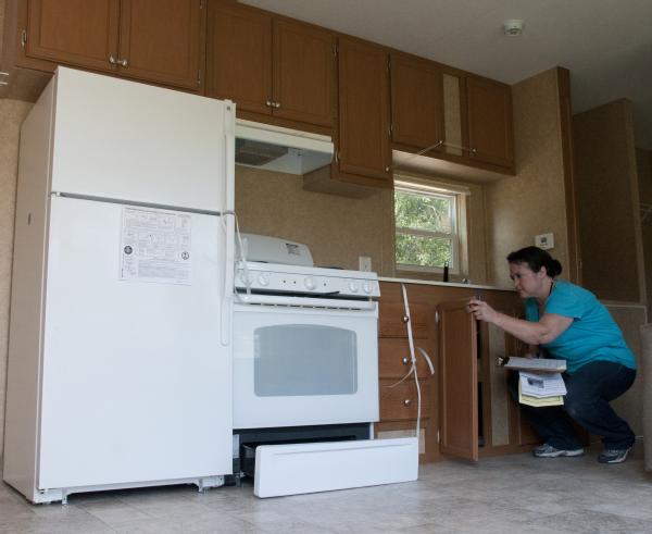 A FEMA housing specialist inspects the kitchen in a small temporary housing unit that will be provided to an Arkansas resident whose home was damaged during the recent storms that swept across Arkansas.