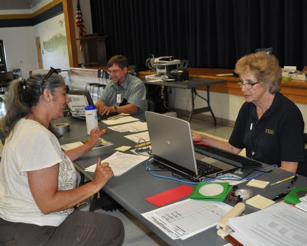 Applicant assistant Marie Hanzel reviews a disaster survivor’s case at the Carroll Country disaster recovery center.