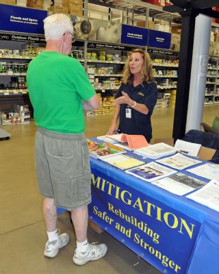 Mary Kay Leford, FEMA hazard mitigation specialist, discusses building safe rooms with Lowe's customer, Jack Kelley. Hazard mitigation specialists are providing information on how homeowners and business can rebuild at building supply stores in the declared counties.