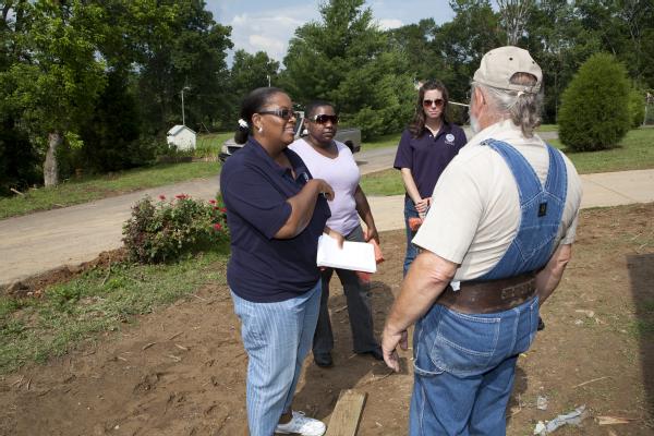 Big Rock, TN, June 15, 2011 -- Foudiya Henri (left), a community relations field worker, talks with Tom Whitehawk as Shavonne Westerfield, Tennessee Emergency Management Agency, and Kristen McEnroe (background), Federal Coordinating Officer Cadre listen in. Community relations field workers are often the first face-to-face contact many survivors have with the agency.