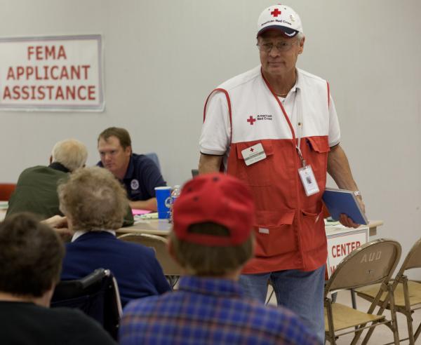 Red Cross volunteer, Phil Wendel talks to disaster survivors at the FEMA/State Disaster Recovery Center in the auditorium in South Minot, N.D.