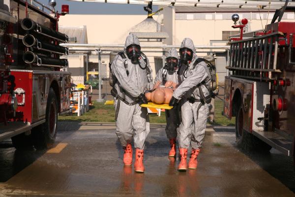 Mayor Richard Hildreth (pictured front-left), of Pacific, Wash., assists his team of emergency responders transport a simulated survivor through the initial stage of decontamination during an exercise.