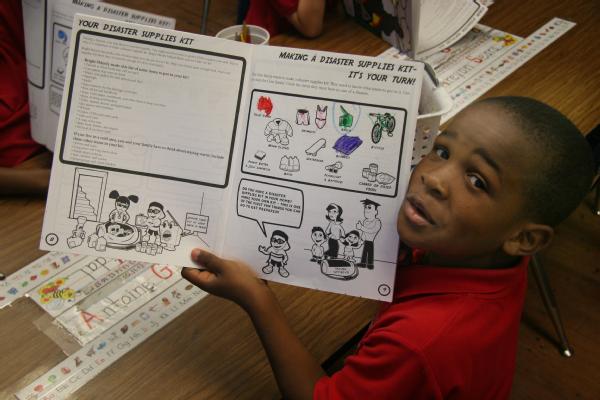 A first grade student at Westwego Elementary School shows off his work as his class works through the FEMA for Kids activity books