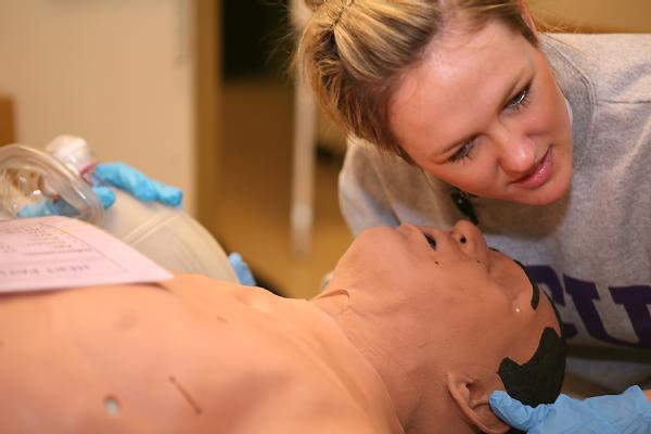 Michelle Hollingsworth, a registered nurse, listens for breathing following simulated life-saving measures during the Hospital Emergency Response Training (HERT) for Mass Casualty Incidents course.