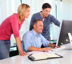 Three people viewing a computer screen