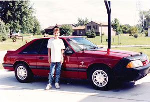 Image of Ryan White standing infront of his new car.