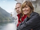 Smiling couple leaning on cruise ship railing