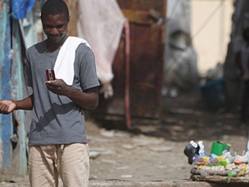 A man walking in the street with a cell phone