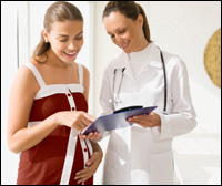 Una mujer embarazada en consulta con una profesional de la salud