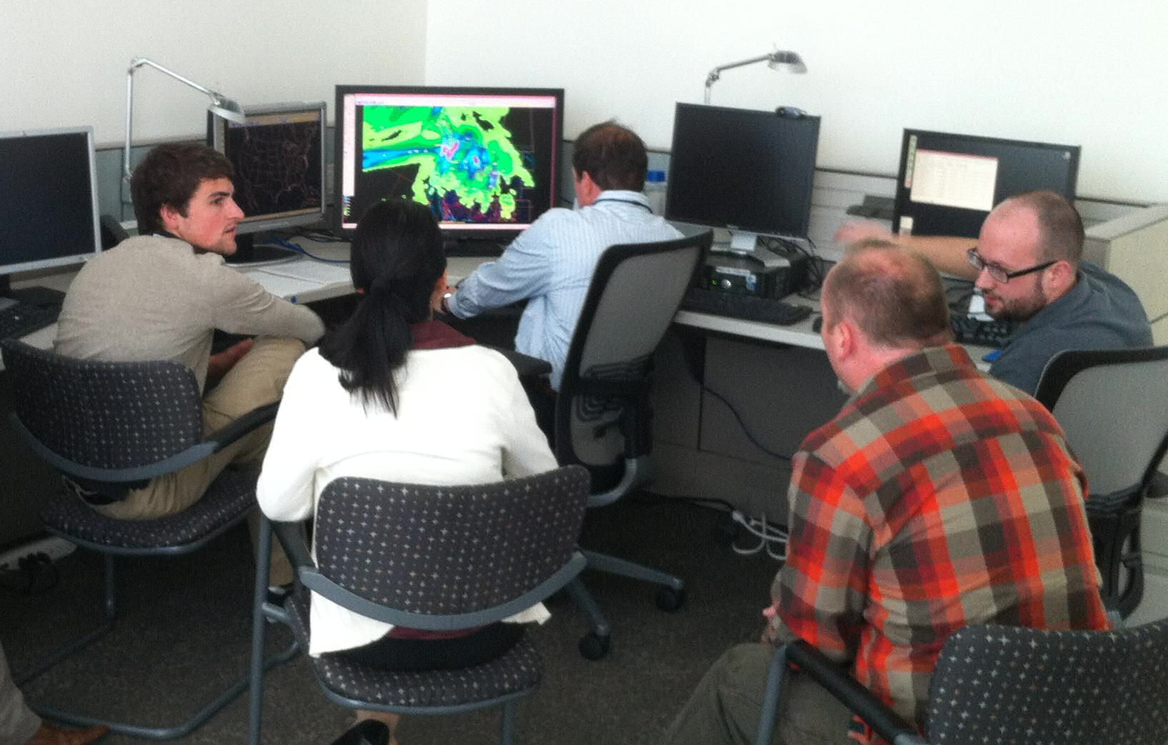 ARRFEX participants discuss the numerical models before making their forecast. (Photo credit: Dave Novak, HPC). From left to right: Ben Moore (ESRL), Yan Luo (EMC), Kenny James (HPC), Victor Stegemiller (NWRFC), and Jon Rutz (Univ. Utah).