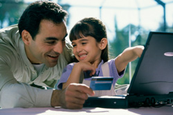 Foto de padre e hija mirando el computador