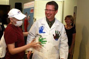 Hyundai Hope On Wheels handprint ceremony where young cancer patients placed their paint-coated, colorful handprints on Orentas' lab coat