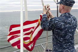 Hospital Corpsman 3rd Class Micheal Manning, a Greenville, N.C., native aboard the USS Bataan (LHD 5), conducts shifting of the colors at Naval Station Norfolk, Va., Dec. 11, 2012. Shifting of the colors is a common practice for any naval vessel while pulling out of port, lowering the ensign from aft of the ship and raising it midship. (U.S. Marine Corps Photo by Cpl. Kyle N. Runnels/Released)