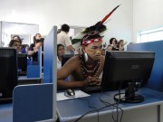 Man in tribal garb using a computer in a classroom