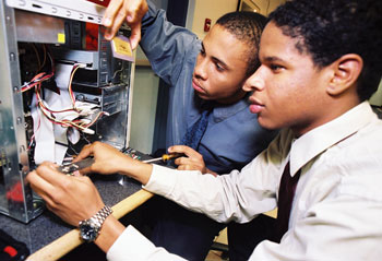 Two students installing components on a computer