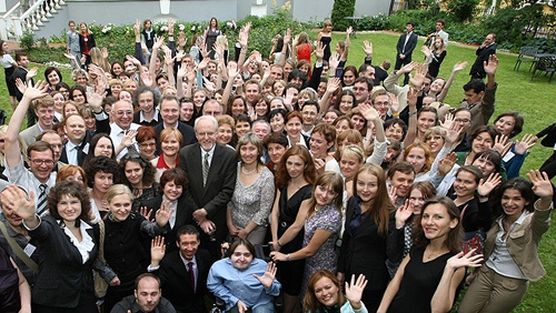 A large group of people waving. State Dept. Photo