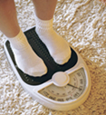 Image of person stepping on weight scale