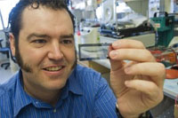 Clare McLean
Dr. Brian O'Roak holds a flow cell on which DNA
samples are loaded for sequencing. The imaging
and chemical analysis of the sample all take place
on the slide

