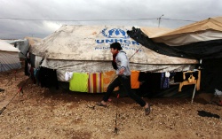 Date: 01/08/2013 Description: A Syrian refugee boy runs to his family tent at Zaatari Syrian refugee camp, near the Syrian border in Mafraq, Jordan.  © AP Image