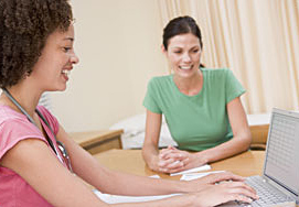 Two Smiling Women One Typing on a Computer