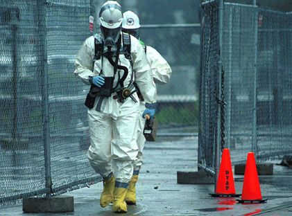 Chemical spill response worker in hazmat suit.