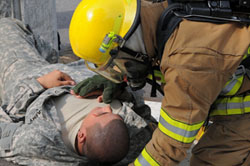 Photo fireman attending a soldier lying down