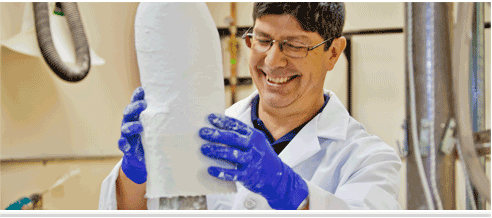 A smiling man making a cast or prosthetic.