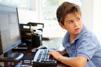 Un niño pequeño sentado frente a una computadora