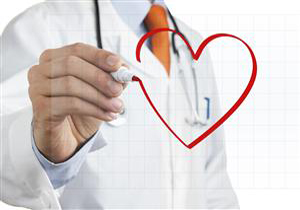 A male doctor in the background drawing a red heart symbol on an interactive whiteboard.