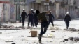 An anti-government protester throws a stone towards riot police during clashes in Daih, Bahrain, February. 14, 2013.