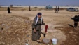 An elderly Syrian woman, who fled her home due to government shelling, washes her laundry in tub, as she takes refuge at Bab Al-Salameh crossing border near the Syrian town of Azaz, September 13, 2012. 
