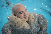 Sgt. Cristhian Perez, combat engineer, Combat Instructor Company      , The Basic School, uses his trouser to float during the swim qualification in the Ramer Hall pool at The Basic School on Feb. 4. Both the uniform trousers and blouse can be used as a flotation device once filled up with air.