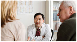 An image of a male health professional speaking with older male and female patients