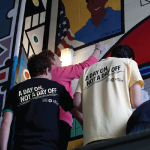 Students help paint a mural on MLK Day