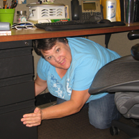 Woman demonstrating Drop, Cover, and Hold On