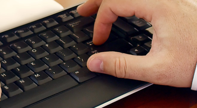 Hands typing on a computer keyboard