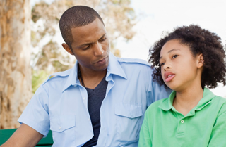 Father talks to son on a bench