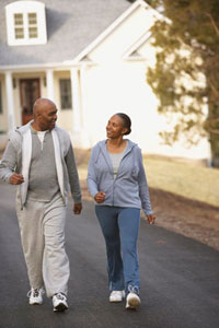 An image of an older, African-American couple walking in a neighborhood
