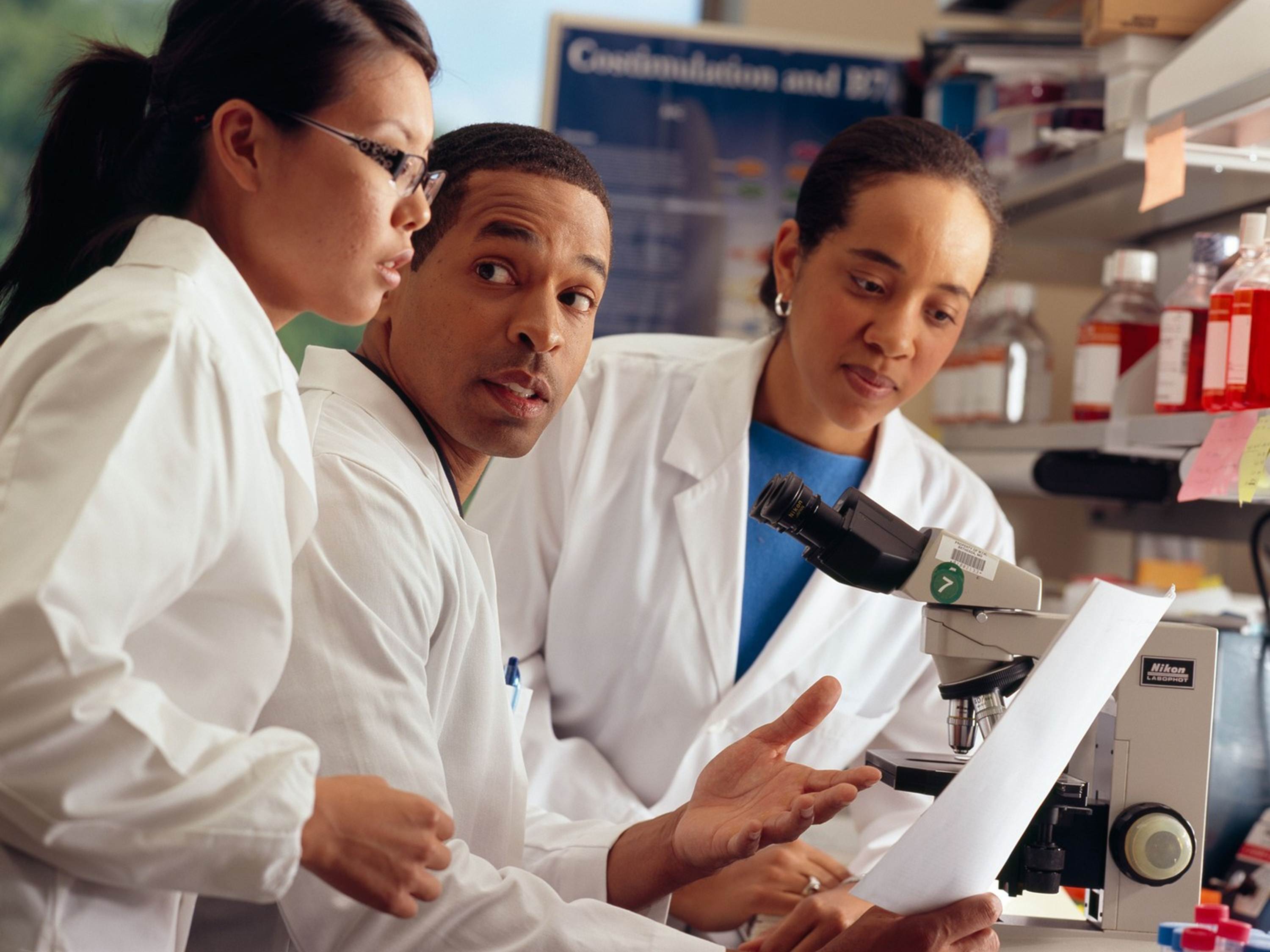 Photo of three young minority scientists in a lab (NCI Photo).