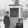 boy standing next to early meteorological field station