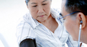 A doctor takes a woman's blood pressure