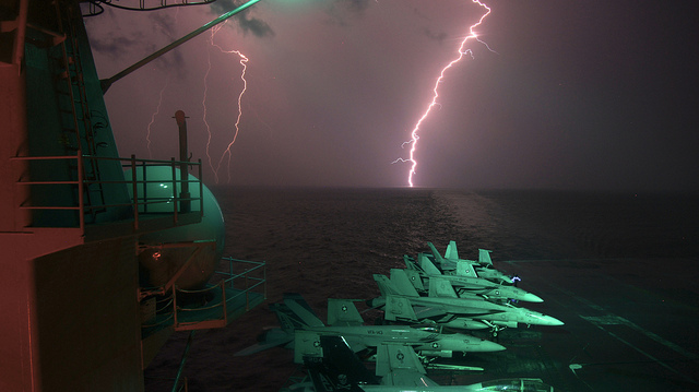 Image description: Flashes of lightning are seen over the horizon as the aircraft carrier USS Dwight D. Eisenhower operates in the Persian Gulf area.
Photo by Lt. Greg Linderman, U.S. Navy.