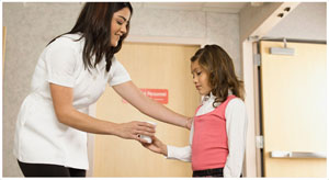 An image of a girl being handed a urine sample cup from a nurse