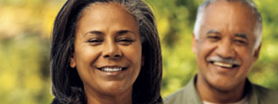 A man and woman stand next to each other and smile