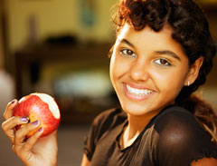 A girl eating an apple.